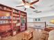 Upstairs living room with a custom bookcase, ceiling fan, and comfortable seating, perfect for relaxation and reading at 12706 W Pasaro Dr, Peoria, AZ 85383