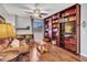 Cozy living room boasts a custom bookcase, ceiling fan, and comfortable seating, ideal for relaxation and reading at 12706 W Pasaro Dr, Peoria, AZ 85383