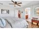 Bright main bedroom with hardwood floors, a ceiling fan, and an en-suite bathroom for added privacy and convenience at 12706 W Pasaro Dr, Peoria, AZ 85383