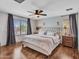 Relaxing main bedroom featuring a luxurious upholstered bed, contemporary curtains, and stylish bedside tables and lamps at 12706 W Pasaro Dr, Peoria, AZ 85383
