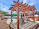 Outdoor kitchen area with BBQ, pergola with cafe lights and nearby swimming pool at 12706 W Pasaro Dr, Peoria, AZ 85383