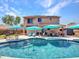Large backyard pool with covered patio, seating area, and lush landscaping at 12706 W Pasaro Dr, Peoria, AZ 85383