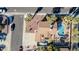 Aerial view showcasing the house, roof, driveway, desert landscape and pool area with green grass and trampoline at 13051 N 75Th Dr, Peoria, AZ 85381