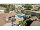 Aerial view of the backyard of the house, showcasing a refreshing pool, a trampoline, and outdoor dining and lounging areas at 13051 N 75Th Dr, Peoria, AZ 85381