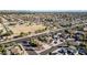 Wide aerial view showcases desert landscaping, pool, house, and neighborhood with a large open area in the distance at 13051 N 75Th Dr, Peoria, AZ 85381