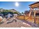 Backyard with a fire pit, chairs, wooden fence, partial view of the house and trampoline in the background at 13051 N 75Th Dr, Peoria, AZ 85381