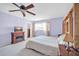 Comfortable bedroom with television, ceiling fan, and bright light from the window at 13051 N 75Th Dr, Peoria, AZ 85381
