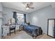 Light-filled bedroom features a ceiling fan, desk, and neutral carpet at 13051 N 75Th Dr, Peoria, AZ 85381
