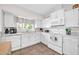 Bright, white kitchen featuring tile floors, plentiful cabinetry and countertops, and a window over the sink at 13051 N 75Th Dr, Peoria, AZ 85381