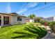 Backyard featuring artificial turf, lush landscaping, and a putting green at 13601 N 50Th Pl, Scottsdale, AZ 85254