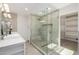 Bright bathroom featuring a luxe glass enclosed shower with bench, storage, and dual vanity at 13601 N 50Th Pl, Scottsdale, AZ 85254