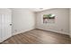 Bright bedroom with wood-look flooring, white walls, and a window letting in natural light at 13601 N 50Th Pl, Scottsdale, AZ 85254