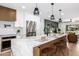 Modern kitchen island with marble countertops, seating, and decorative pendant lights at 13601 N 50Th Pl, Scottsdale, AZ 85254
