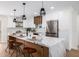 Kitchen island with marble countertop, seating, and modern pendant lighting at 13601 N 50Th Pl, Scottsdale, AZ 85254