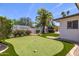 Backyard putting green surrounded by manicured landscaping and mature trees at 13601 N 50Th Pl, Scottsdale, AZ 85254
