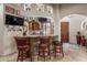 Stylish bar area featuring stone accents, granite countertops, and comfortable seating for entertaining guests at 14538 W Sheridan St, Goodyear, AZ 85395
