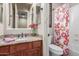 The bathroom has granite countertops, and a shower tub combo with a patterned curtain at 14538 W Sheridan St, Goodyear, AZ 85395
