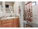 This bathroom has granite countertops, a light wood vanity and a shower/tub combo at 14538 W Sheridan St, Goodyear, AZ 85395