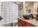 Bathroom featuring granite countertop, decorative vessel sink and a shower/tub combo with a curtain at 14538 W Sheridan St, Goodyear, AZ 85395