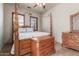 This bedroom has a four poster bed with wooden furniture and tile flooring at 14538 W Sheridan St, Goodyear, AZ 85395