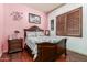 Cozy bedroom with wood floors, and a comfortable bed bathed in light coming through the plantation shutters at 14538 W Sheridan St, Goodyear, AZ 85395