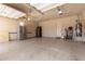 Spacious garage with epoxy flooring, two refrigerators, and ample storage space at 14538 W Sheridan St, Goodyear, AZ 85395