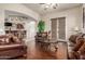 Well-lit living room featuring a comfortable leather sofa, with a view of the adjacent bar area at 14538 W Sheridan St, Goodyear, AZ 85395