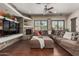 Spacious living room features a stone fireplace, wooden floors, and large sectional sofa at 14538 W Sheridan St, Goodyear, AZ 85395