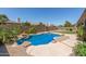 Gorgeous backyard pool surrounded by lush vegetation, stone accents, and an inviting patio area at 14538 W Sheridan St, Goodyear, AZ 85395