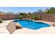 Beautiful pool featuring rock accents, lush landscaping, and a private backyard setting at 14538 W Sheridan St, Goodyear, AZ 85395