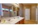 Bathroom features a double sink vanity with a large mirror, a shower, and neutral-toned walls at 16807 W Carmen Dr, Surprise, AZ 85388