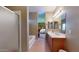 Bright bathroom featuring double sinks, a tub, separate shower, and a view into the main bedroom at 16807 W Carmen Dr, Surprise, AZ 85388