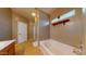 Bright bathroom features a soaking tub under a window and tile flooring at 16807 W Carmen Dr, Surprise, AZ 85388