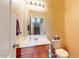 Half bath features a wooden vanity and a mirror with bright lighting at 16807 W Carmen Dr, Surprise, AZ 85388
