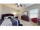 Cozy bedroom featuring a comfortable bed, a dark dresser, and a red accent chair in a relaxed setting at 16807 W Carmen Dr, Surprise, AZ 85388