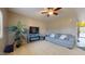 Cozy living room with a ceiling fan, comfortable sofa, fireplace, and a large potted plant at 16807 W Carmen Dr, Surprise, AZ 85388