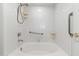 Bright white tiled bathtub with shower features and assist bars at 1747 E Northern Ave # 104, Phoenix, AZ 85020