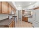 Functional kitchen with wood cabinets, white appliances and tile flooring at 1747 E Northern Ave # 104, Phoenix, AZ 85020