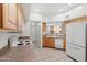 Cozy kitchen featuring wood cabinets, white appliances and tile flooring at 1747 E Northern Ave # 104, Phoenix, AZ 85020