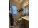 Well-lit bathroom with a single sink vanity, toilet, and decorative mirror at 2014 N 93Rd Dr, Phoenix, AZ 85037