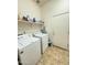 Functional laundry room with washer, dryer, and shelving for storage at 2014 N 93Rd Dr, Phoenix, AZ 85037