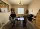 Bright office space with a large desk, ample shelving, and a relaxing view from the window at 2014 N 93Rd Dr, Phoenix, AZ 85037