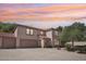 Charming two-story home featuring a tile roof and three-car garage, complemented by a well-maintained front yard at 2061 E Flintlock Way, Chandler, AZ 85286