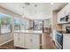 Bright kitchen with a central island, white cabinets, stainless steel appliances and an adjacent dining area at 2061 E Flintlock Way, Chandler, AZ 85286