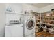 Bright laundry room with modern washer and dryer and ample shelving at 2061 E Flintlock Way, Chandler, AZ 85286