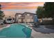 Backyard pool with patio and outdoor furniture for entertaining under colorful sunset at 2061 E Flintlock Way, Chandler, AZ 85286