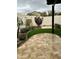 A serene backyard featuring low-maintenance artificial turf, a paved patio, mature trees, and attractive landscaping at 20962 W Thomas Rd, Buckeye, AZ 85396