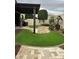 Landscaped backyard featuring artificial grass, stone pavers, and a pergola, offering a relaxing outdoor space at 20962 W Thomas Rd, Buckeye, AZ 85396