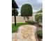 Beautifully landscaped backyard featuring a paver patio, artificial grass, and mature shade trees at 20962 W Thomas Rd, Buckeye, AZ 85396