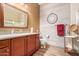 Well-lit bathroom with a framed mirror, granite countertop vanity, and a glass-enclosed shower at 20962 W Thomas Rd, Buckeye, AZ 85396